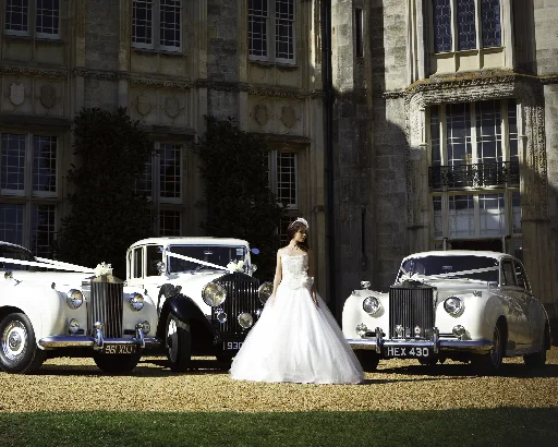 Bride standing between three classic Rolls-Royce wedding cars