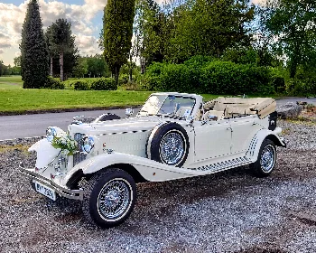 Ivory vintage-style Beauford convertible with its roof folded down and flowers on the front