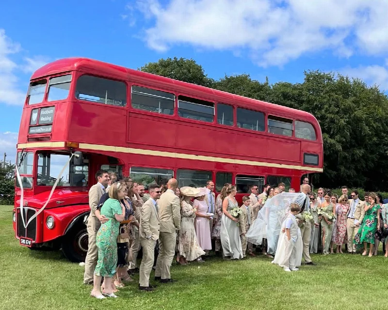 Vintage Routemaster with Wedding Guests posing for photos in front of the bus