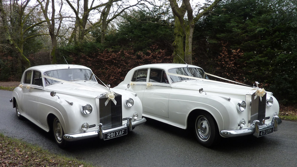 Two White Classic Rolls-Royce Silver Cloud standing side by side with Ribbons
