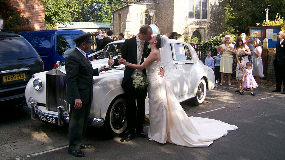 Classic White Rolls-Royce with couple and their wedding chauffeur on the day of their wedding