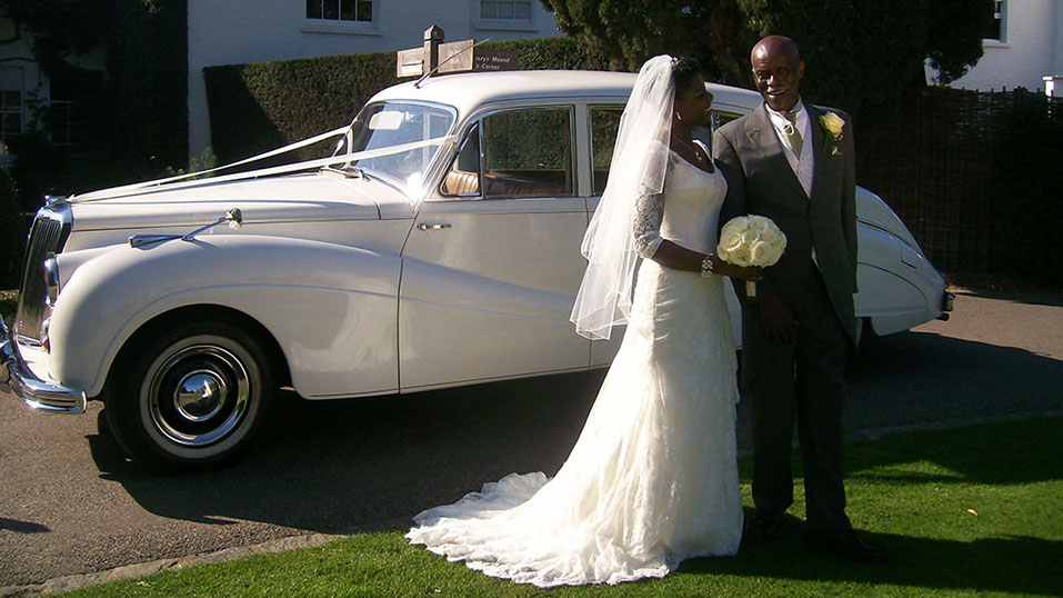couple in front of their classic Armstrong-Siddeley Limousine they have hired