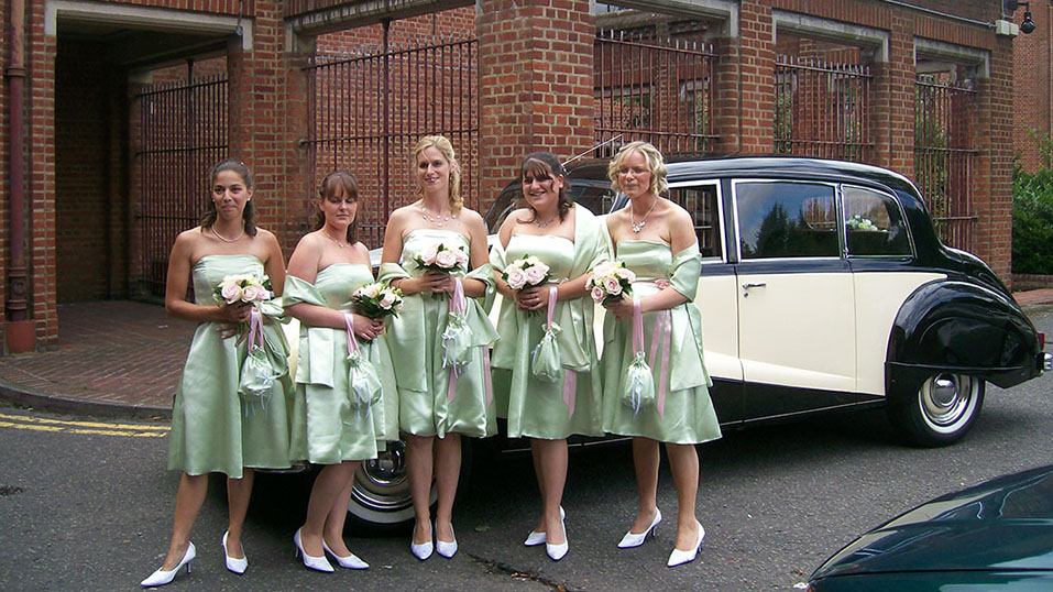 bride and her bridesmaids in pale green colour theme in front of the car