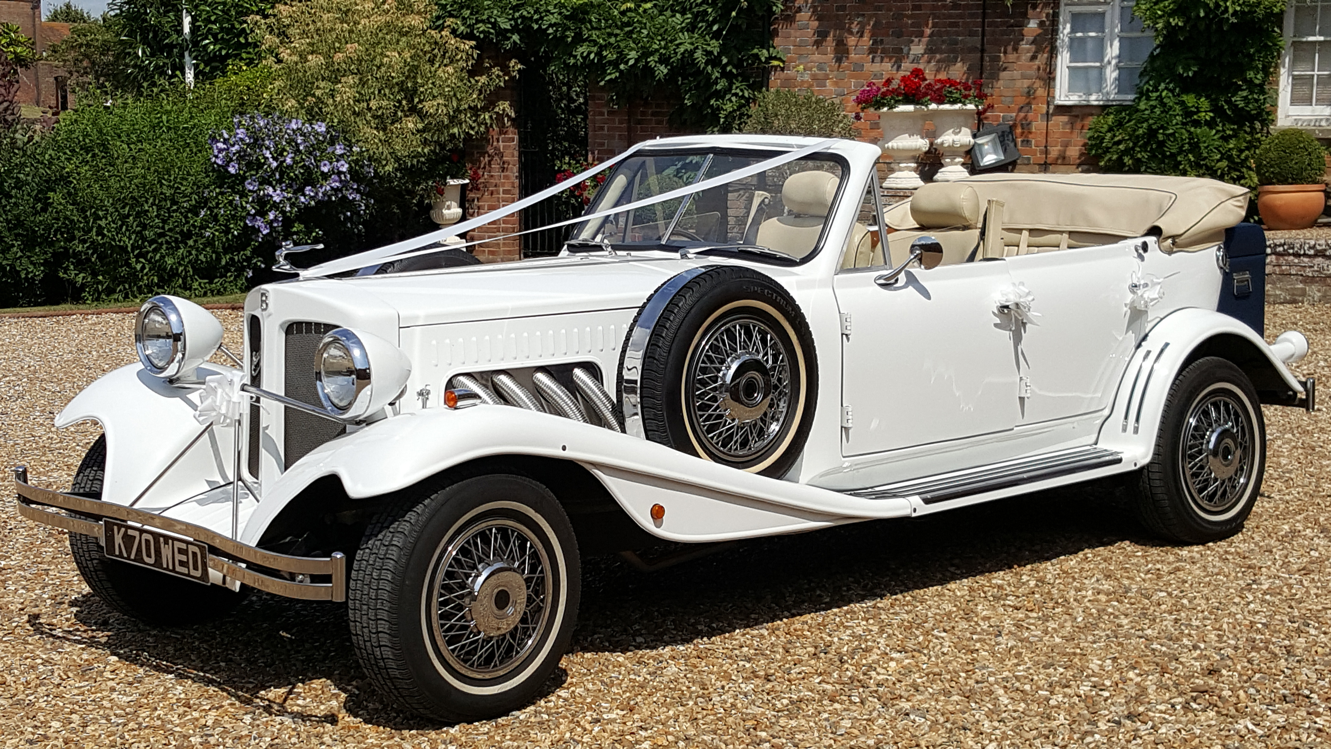 White vintage beauford convertible with roof down and white ribbons