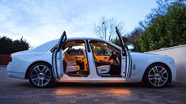 White rolls-royce with doors open showing cream leather interior