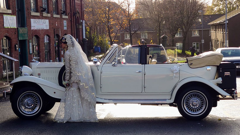 Asian Wedding Bride standing by her vintage Beauford car at Anchor Plaza, Manchester