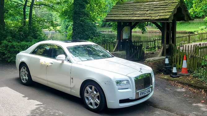 White Rolls-Royce Ghost waiiting for bride and groom in front of venue
