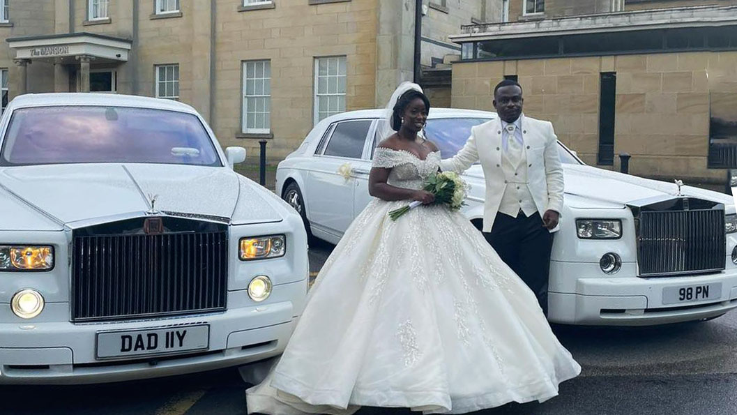 Bride and Groom posing for photos next to their two white rolls-royce Wedding Cars they have hired