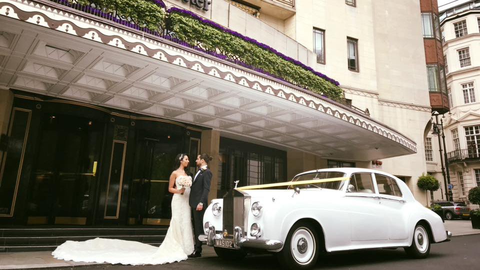 Bride and Groom in Front of the Dorchester Hotel in London with the Classic Rolls-Royce they have booked