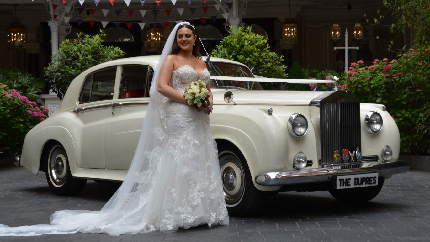Rolls-Royce Silver Cloud with Bride standing by the car with her bridal bouquet in London