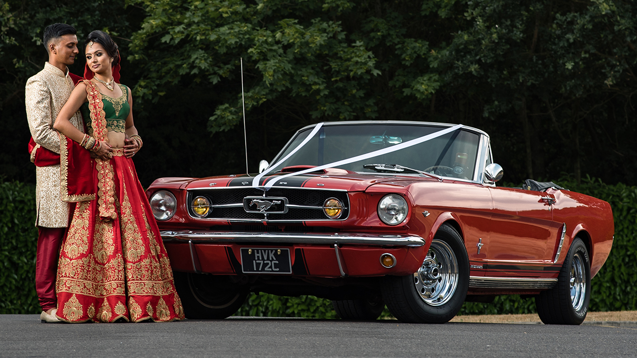 Asian Couple in front of the Classic Car They've hired 