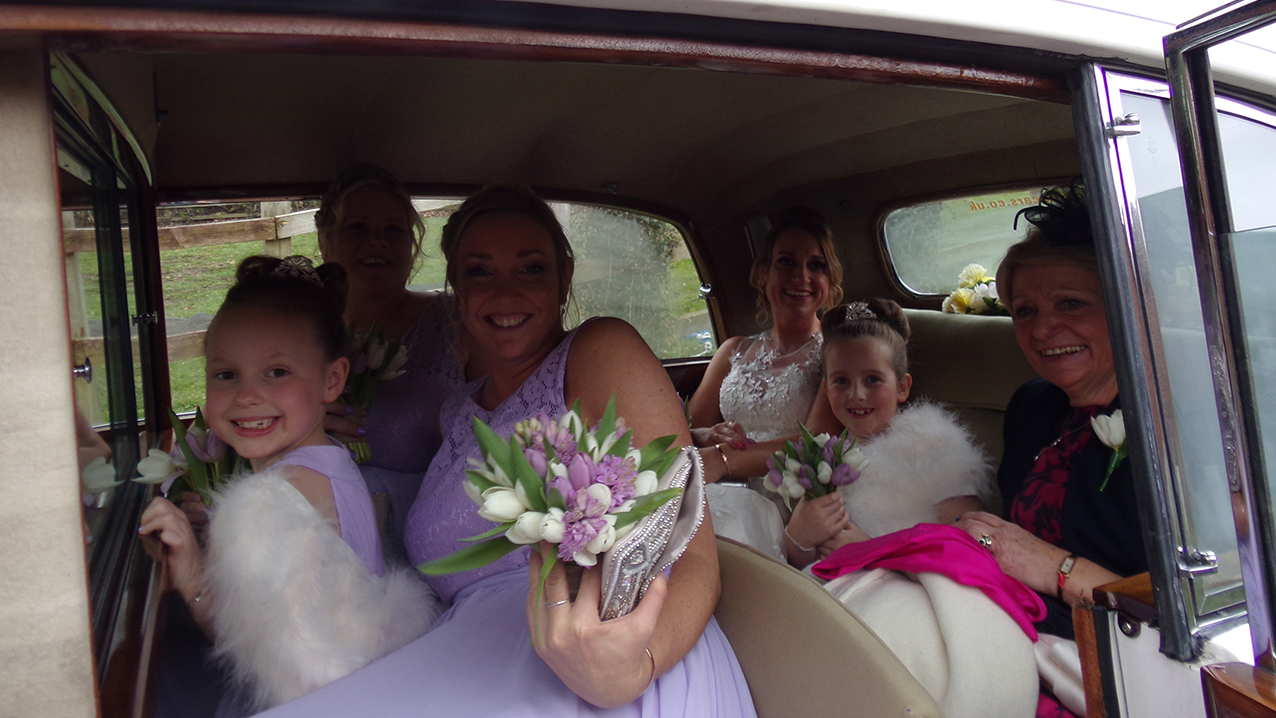 Bride, Bridesmaids and flower girls photo inside the rear cabin of the vehicle. 6 passengers in total