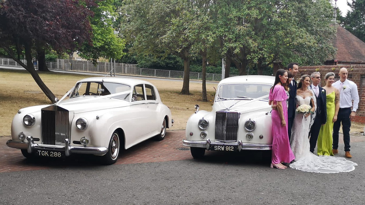 couple with best man and bridesmaids photo in front of the armstrong siddeley and a classic rollsroyce they've hired for their wedding in Uxbridge