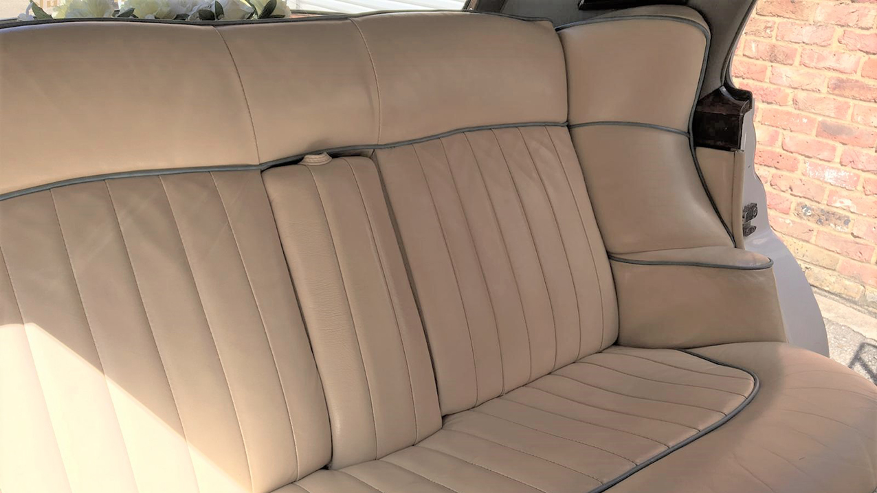 Cream leather interior of the rear bench seat in classic rolls-royce silver cloud