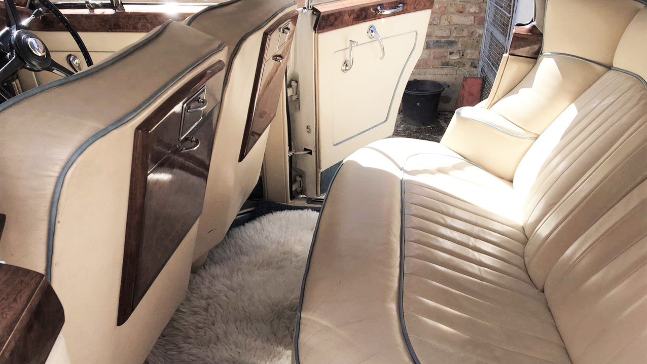 interior photo with cream leather seats and wooden table and dash