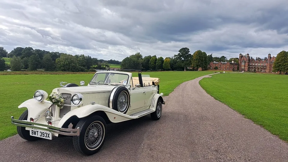 Ivory Convertible Beauford with convertible roof open showing a cream leather seat interior.