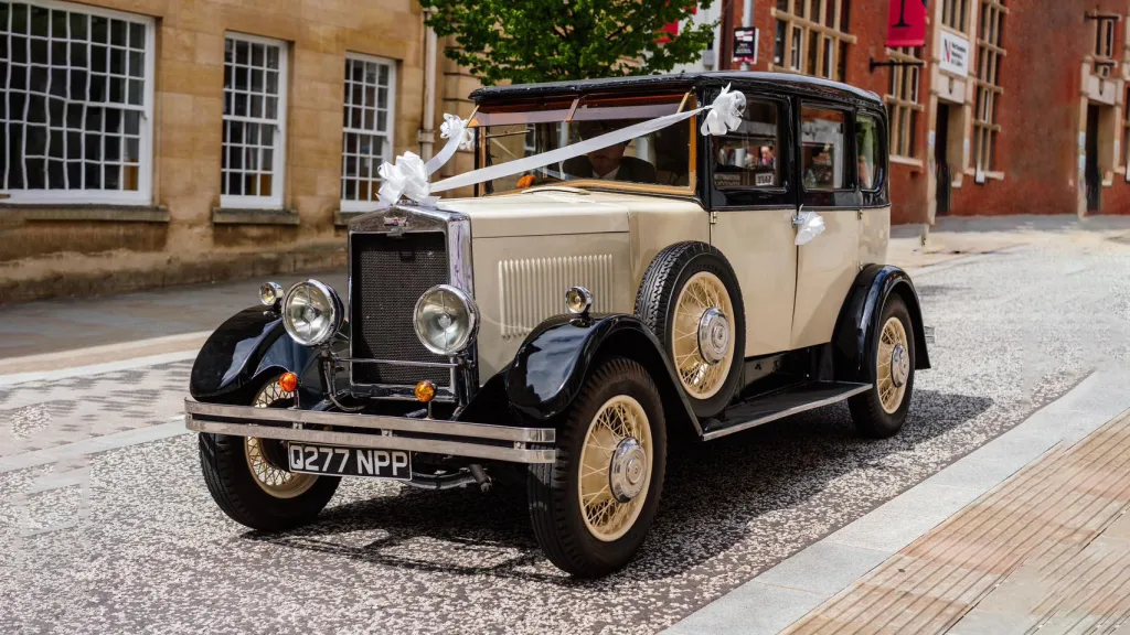 Vintage Black & Ivory Morris cressed with white ribbons and bows. Spare wheel is mounted on the side skirt