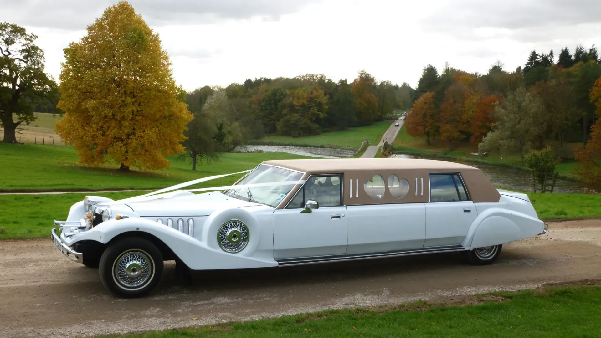 Vitage Style Lincoln Excalibur Limosuine wedding car decorated with wedding ribbons entering venue