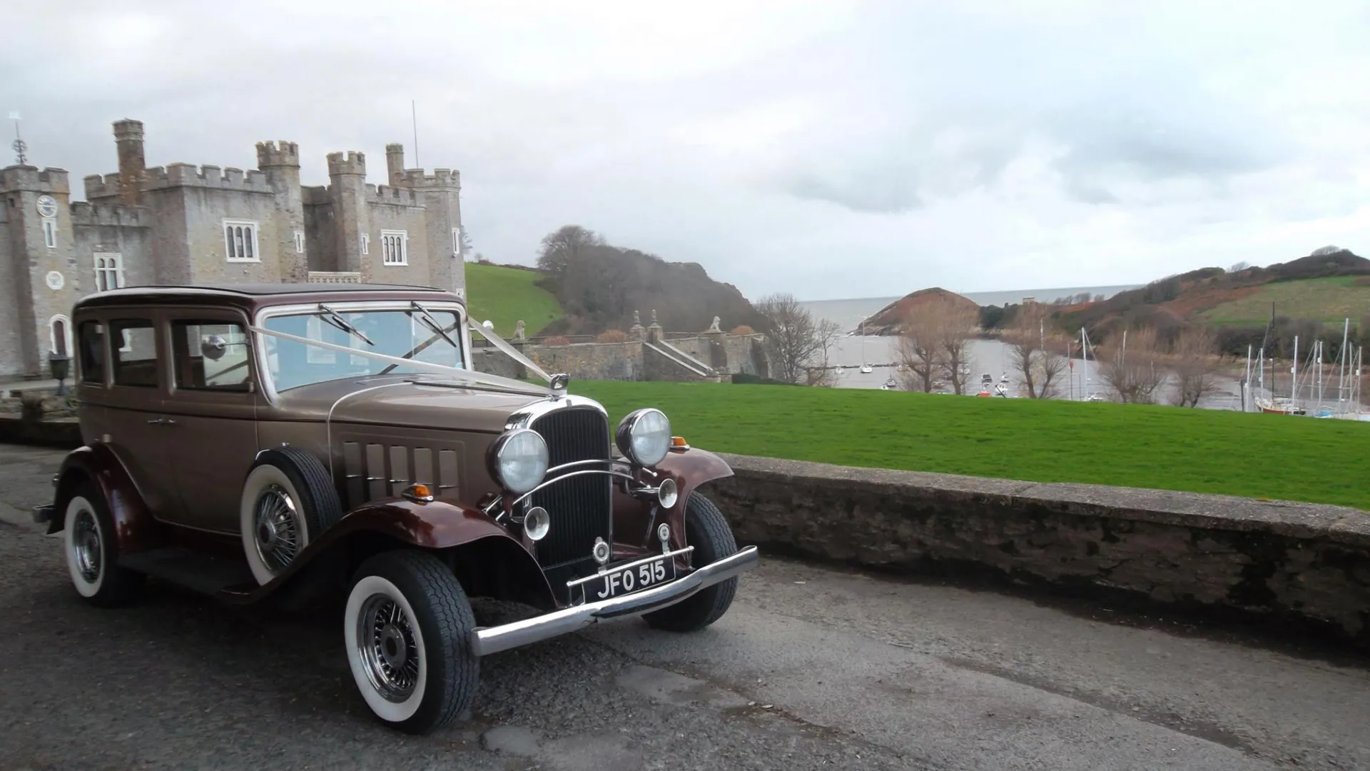 Vintage oldmobile dressed with wedding ribbons in front of Venue