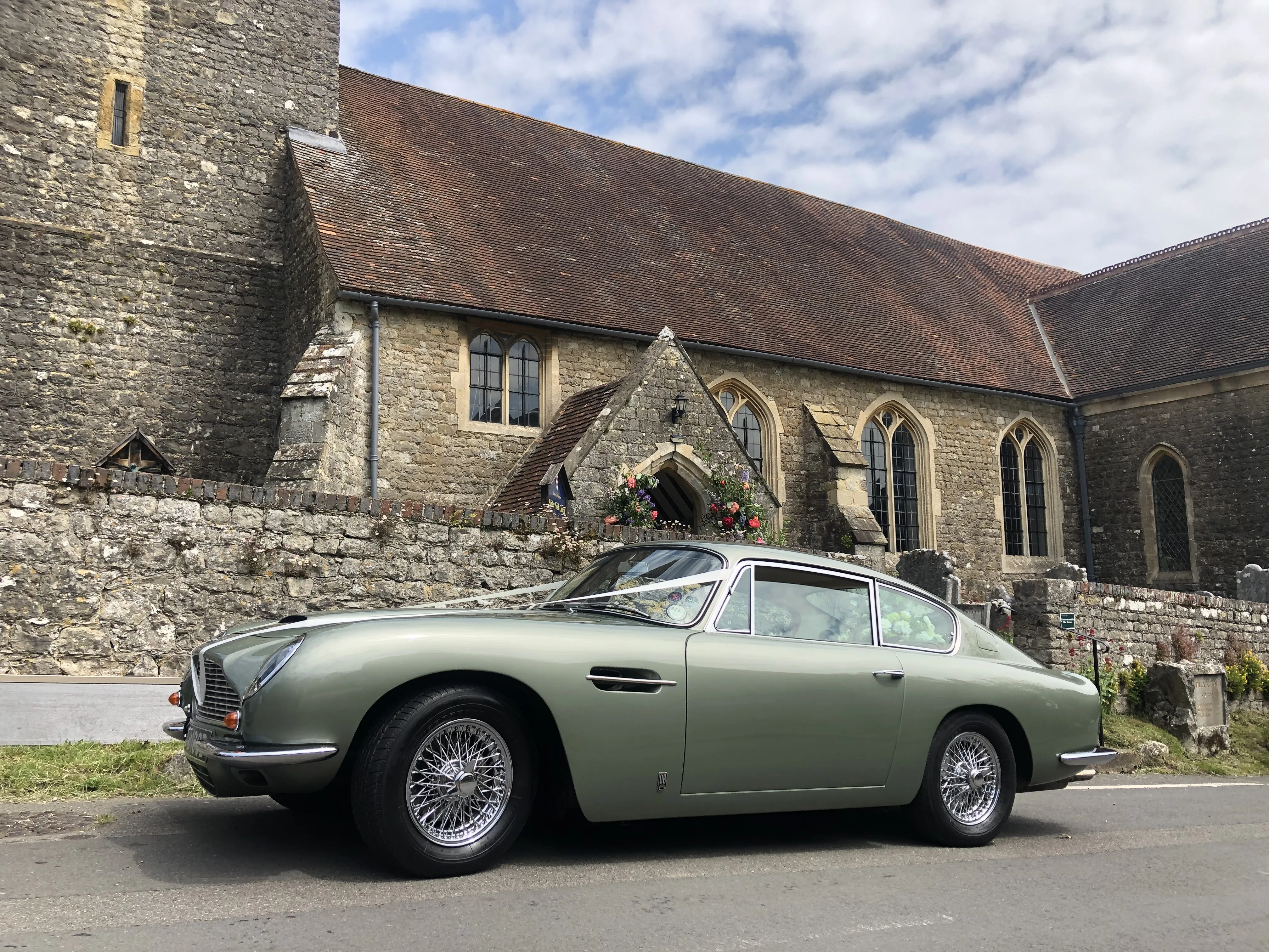 Metallic Green Classic aston Martin DB6 in front of church