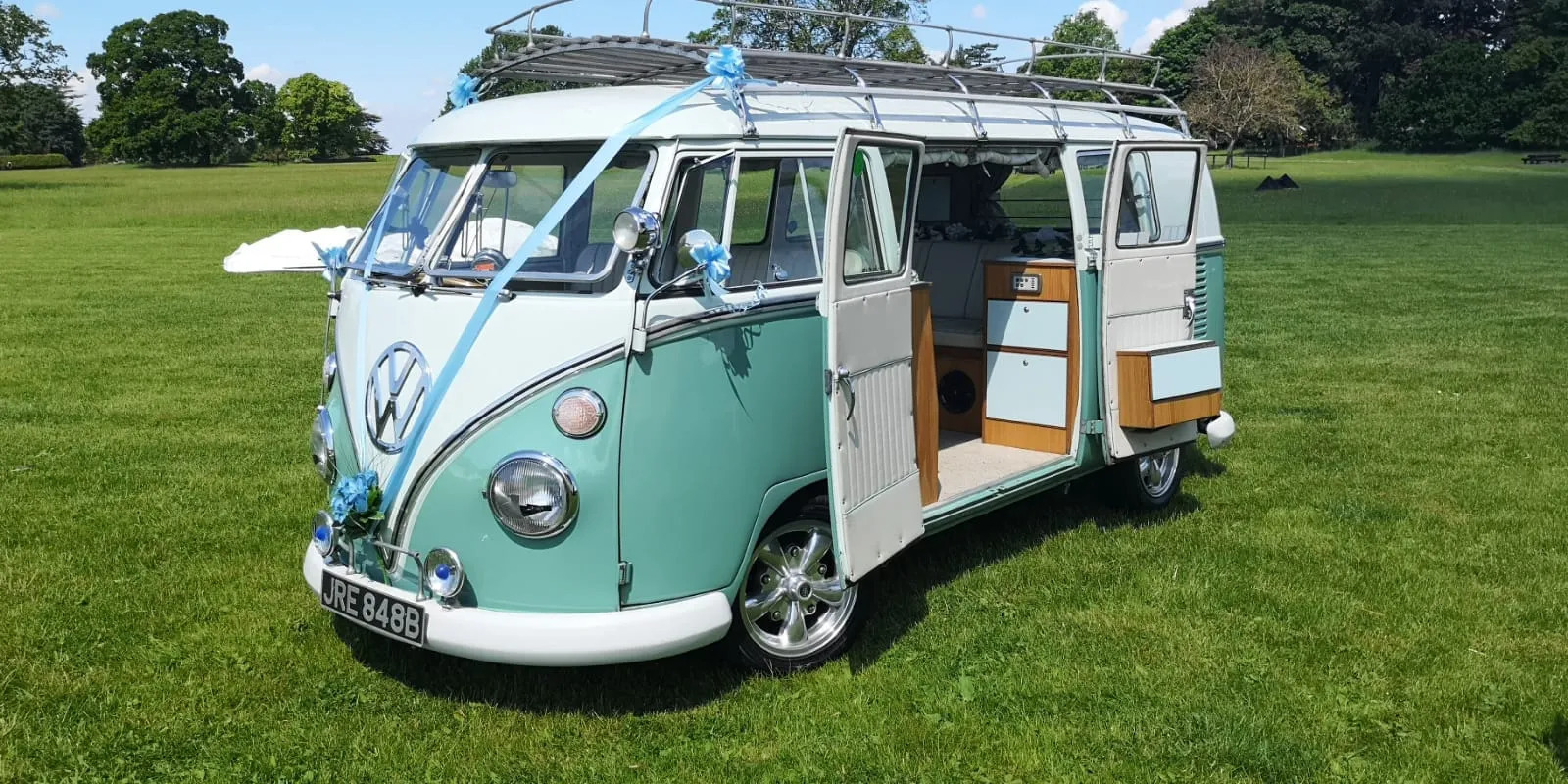 Green and White Classic VW Campervan with side door open