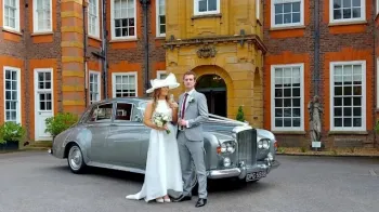 Two Tone Silver Bentley S3 with Bride and Groom standing in front of the vehicle