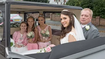 Vintage Imperial in Silver with roof down showing 5 passengers in the rear cabin seating facing each other