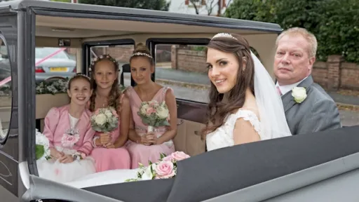 Vintage Imperial in Silver with roof down showing 5 passengers in the rear cabin seating facing each other