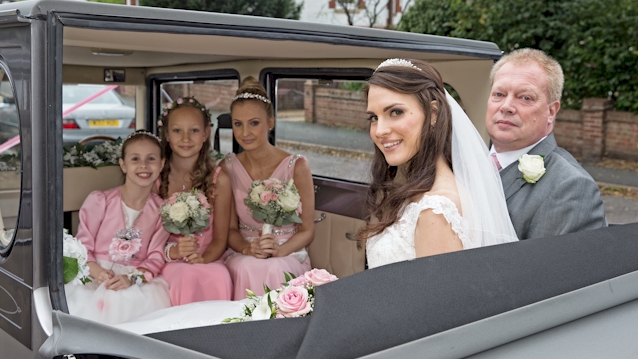 Vintage Imperial in Silver with roof down showing 5 passengers in the rear cabin seating facing each other