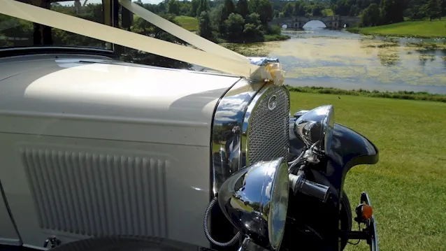 front part of the vintage car showing the chrime grill and large chrome mounted headlights