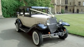 Front Right side view of a Badsworth vintage car in front of a wedding venue with white wall ties and spokes wheels