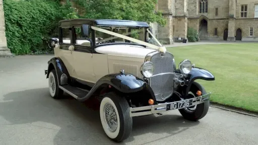 Front Right side view of a Badsworth vintage car in front of a wedding venue with white wall ties and spokes wheels