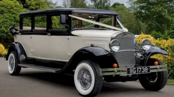 White Vintage Bramwith with Black Wheel arches and roof decorated with white weddng ribbons