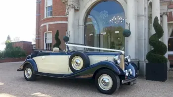 Front view of Blue and Ivory with roof down and white ribbons accroos bonnet