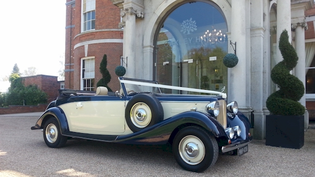 Front view of Blue and Ivory with roof down and white ribbons accroos bonnet