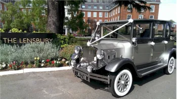 Side view of Imperial decorated with White ribbon. Car has light silver on its body and darker silver grey on top half