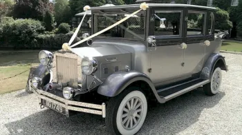 Front Side view of silver imperial dressed with white ribbons and bows. White wheels and large chrome grill