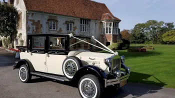 Right front view of Black & Ivory Imperial car decorated with white ribbons and white wall tires
