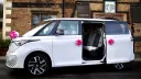 Side view of white modern Electric VW ID Buzz with rear side door open showing the interior seats