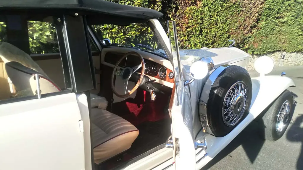 Close up side view with Chauffeur's door pen shwoing the cream leather seats and wooden dashboard