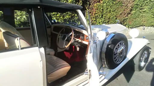Close up side view with Chauffeur's door pen shwoing the cream leather seats and wooden dashboard