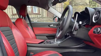 interior front seating area with black and red leather seats