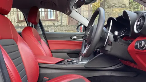 interior front seating area with black and red leather seats