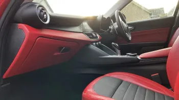 Inside front passenger seat photo with black and red leather seat and matching dashboard