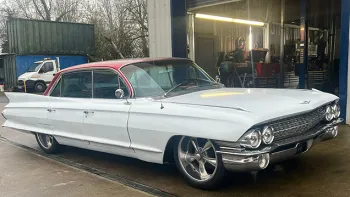 Right Front view os White American Classic Cadillac in front of its garage