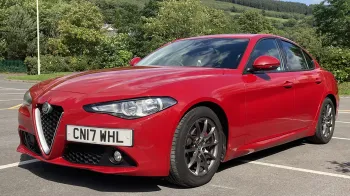 Red Alfa Romeo Giulia in a car park with black alloy wheels