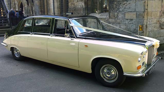 Right Side view of ivory Daimler with Black roof decorated with Light pink Wedding ribbons