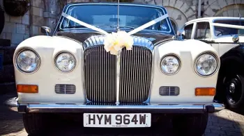 Full front view of Classic Daimler DS420 showing twin headlights and Daimler Chrome Grill with Ivory Bow on top of it