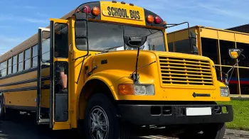 Full front view of American School Bus with double door open and "School Bus" sign at the top