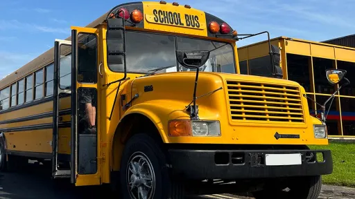 Full front view of American School Bus with double door open and "School Bus" sign at the top